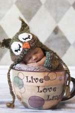 Newborn Baby in Owl Hat Sleeping in a Giant Cup Journal